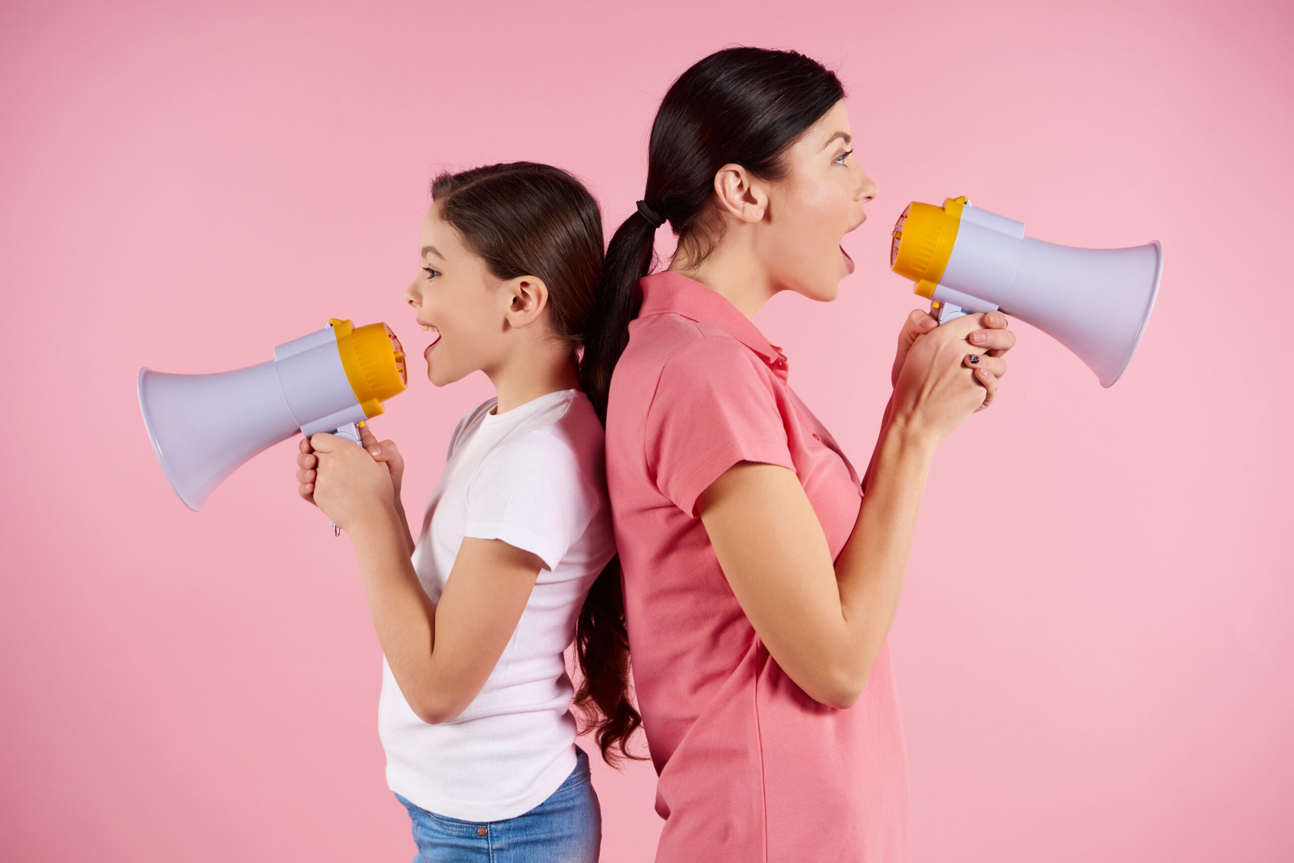 woman girl shouting megaphones standing back back scaled woman girl shouting megaphones standing back back scaled